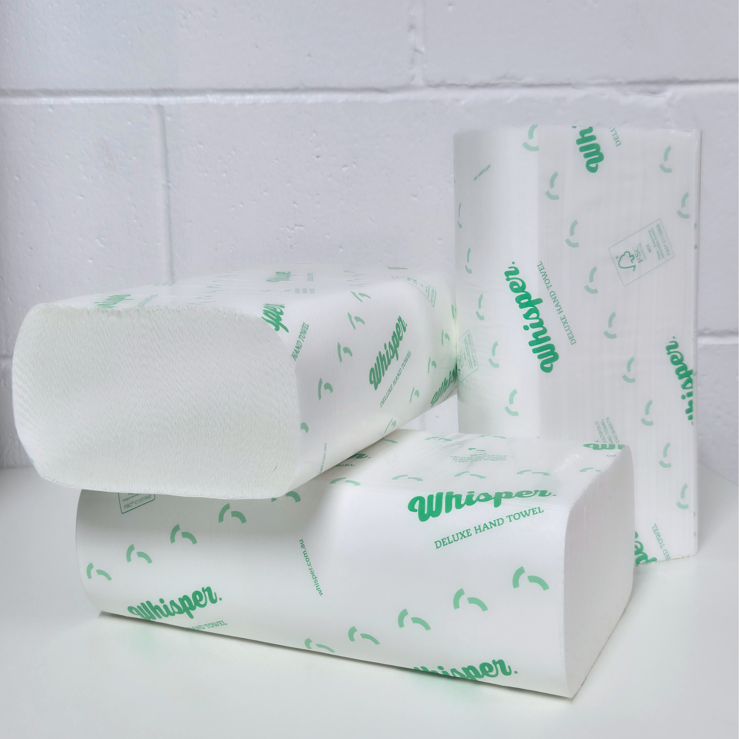 Whisper Deluxe Multifold Slim Hand Towel 1Ply, 3842, white folded paper hand towel, clear and green packaging with writing, white background
