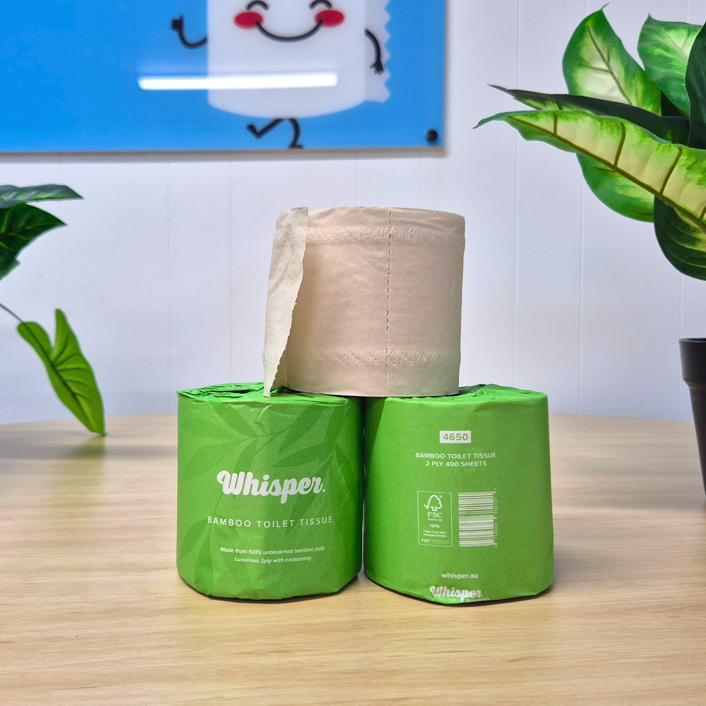4650 whisper bamboo toilet tissue, toilet paper, made from 100% unbleached bamboo pulp, 2ply, green paper wrapper with leaf shadows, on table with plants