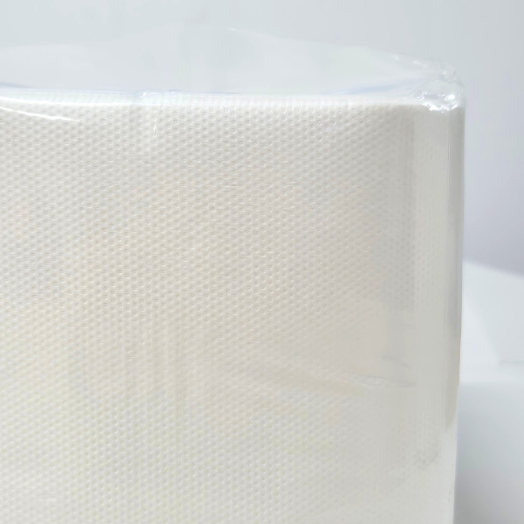 A package of Whisper brand white luncheon napkins, 1 ply, containing 500 napkins. The napkins are wrapped in clear plastic. QT folded napkins. Dot embossing