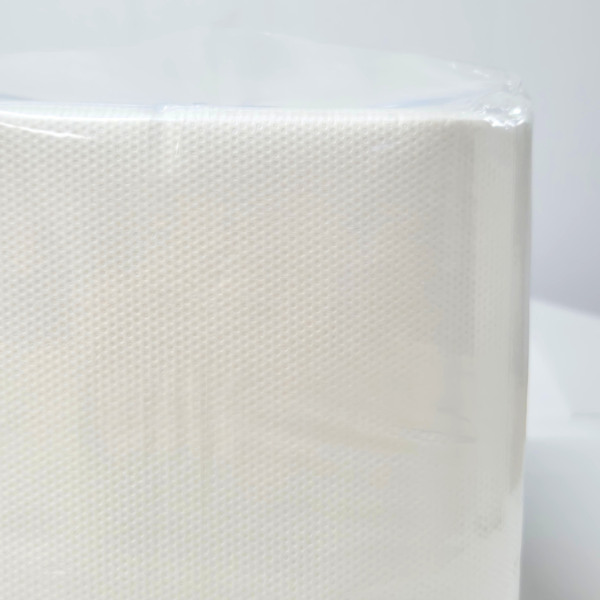 A package of Whisper brand white luncheon napkins, 1 ply, containing 500 napkins. The napkins are wrapped in clear plastic. QT folded napkins. Dot embossing