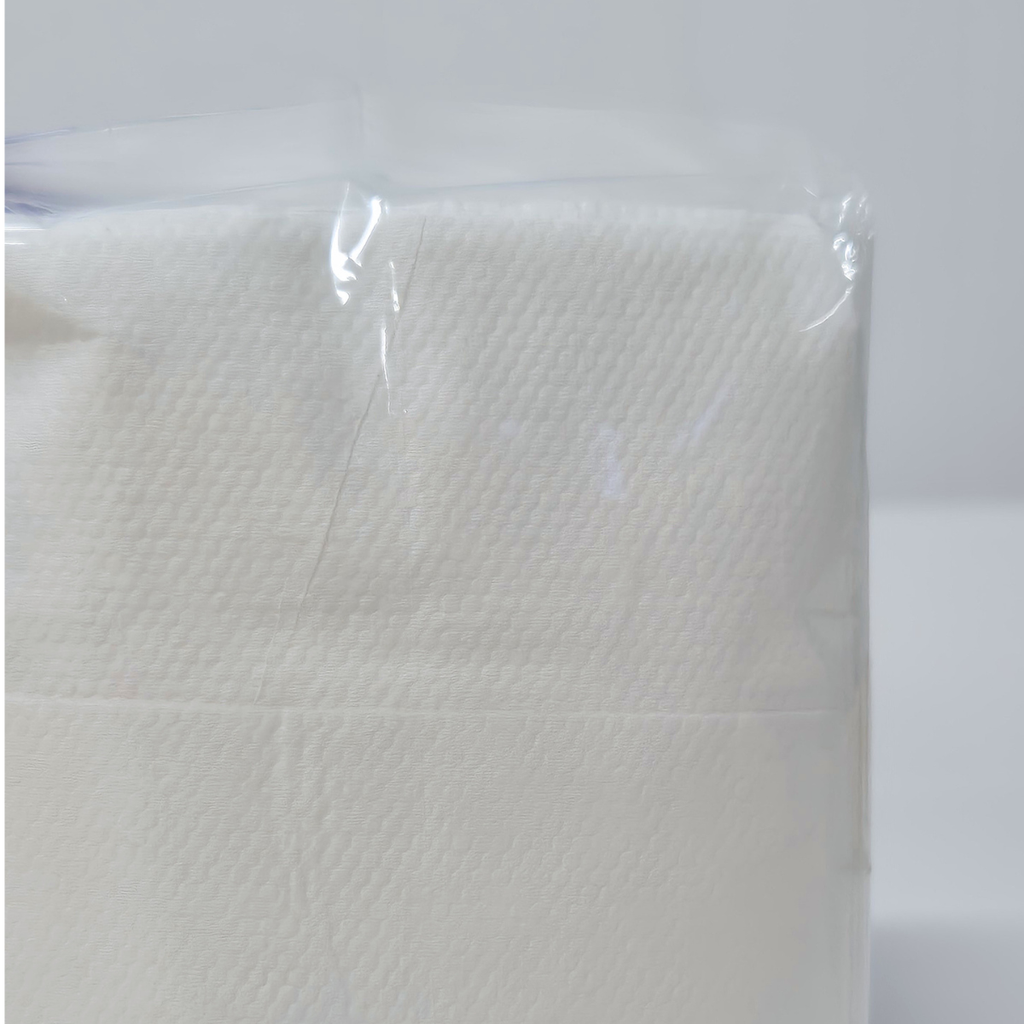 A package of Whisper brand white dispenser napkins in a clear plastic wrap with a purple label, photographed on a white background. D fold napkin, 500 napkins in a pack, 1ply.