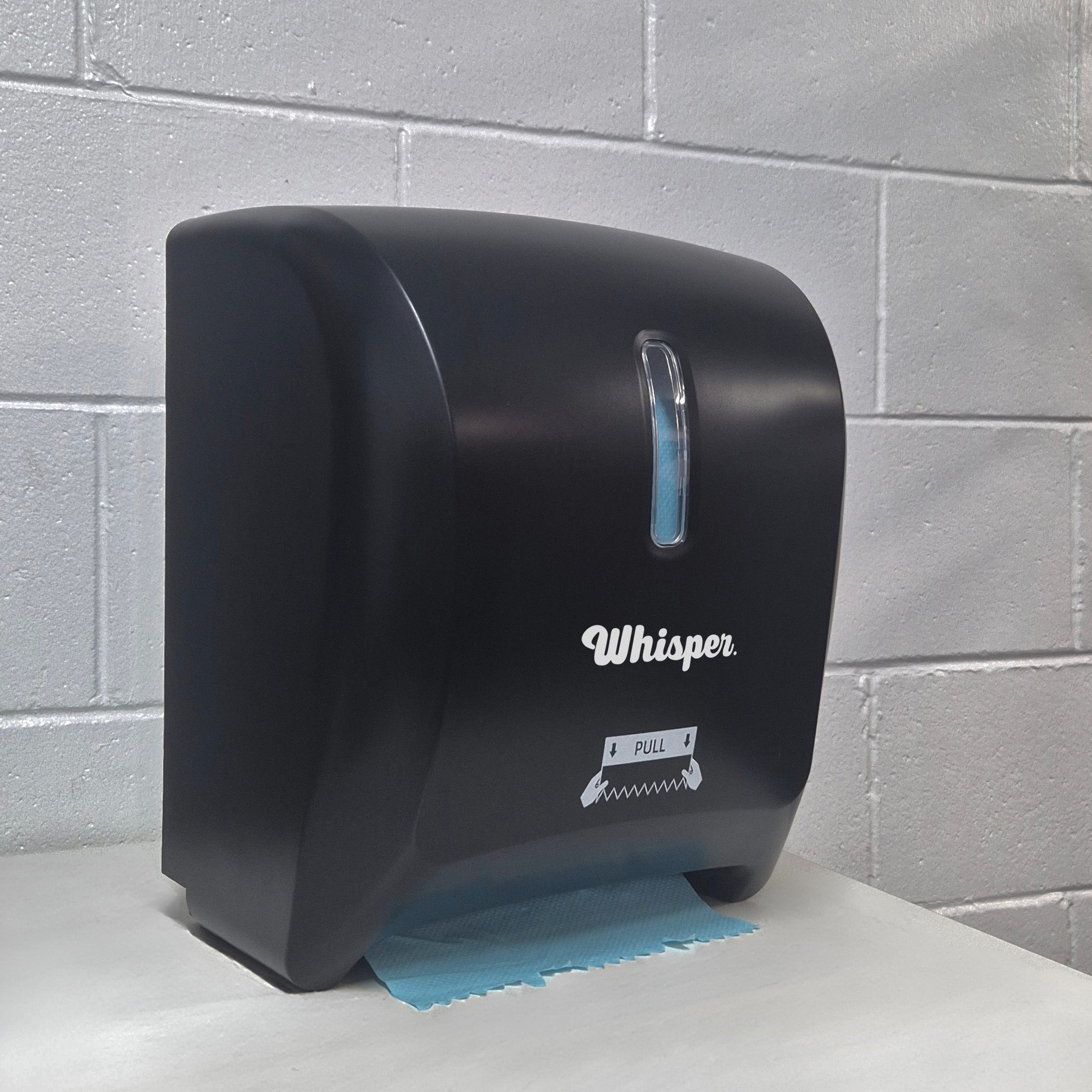 MK8015, Whisper Autocut dispenser, black, white whisper logo, blue paper, roll hand paper towel, white brick background, on white table